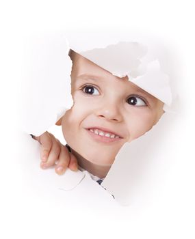 Curious kid looks up through a hole in white paper