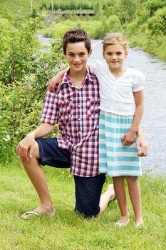Young brother and sister enjoying summer at the cottage near a river in Quebec, Canada.