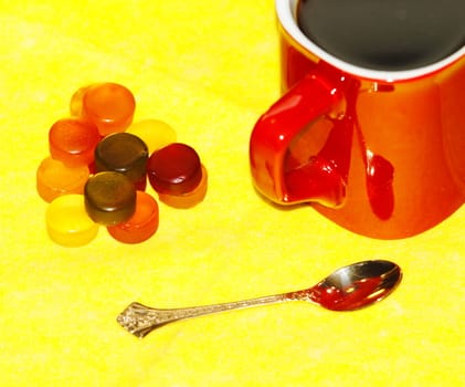 coffee mug, a golden spoon sweets on a yellow background