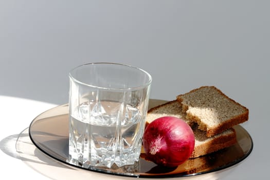 a glass of vodka and on a dark plate on a white background