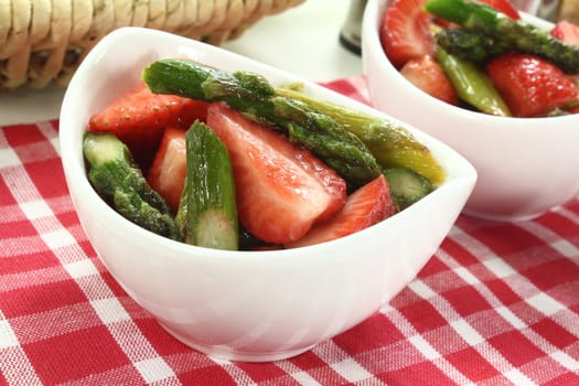 Asparagus salad with fresh strawberries, salt and pepper on a napkin