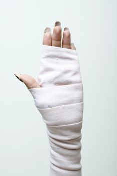 left hand and wrist in thick bandages.