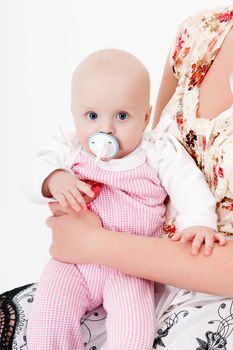 baby girl with a pacifier in her mother's hands