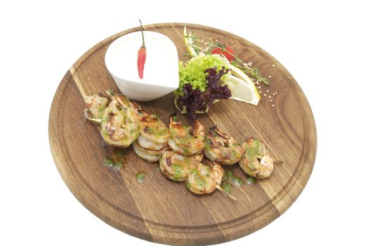 grilled shrimp with a salad on a wooden plate