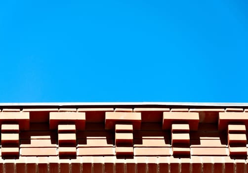 Architectural background - brick eaves against the blue sky.