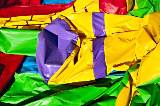 Colored abstract background - a children's amusement, an inflatable castle in a deflated condition.