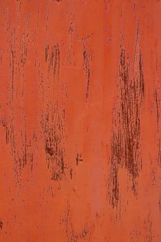 A metal base with orange paint and streaks over rust red.