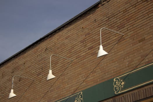 exterior store front lights with a brick wall and blue skies.