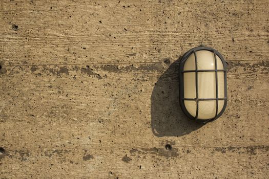 A wall light on a distressed cement or wood wall