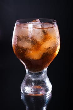 Whiskey with ice in a glass on a black background