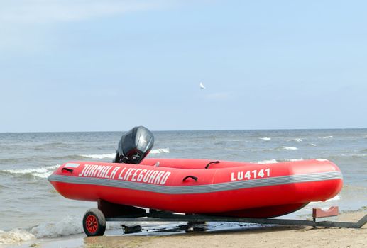 Rubber lifeguard boat on transportation trailer on sea shore.