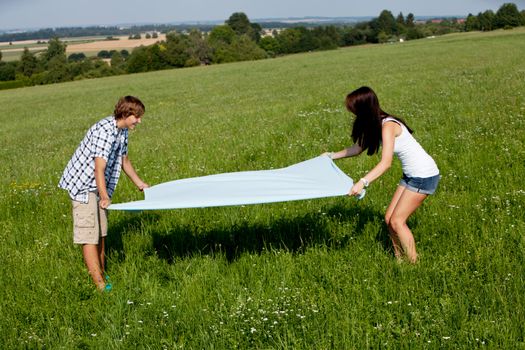 young couple outdoor in summer on blanket in love