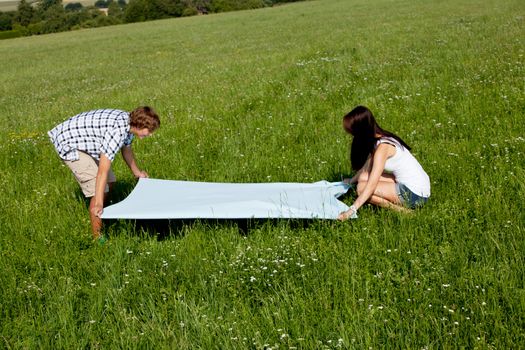 young couple outdoor in summer on blanket in love