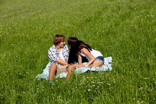 young couple outdoor in summer on blanket in love