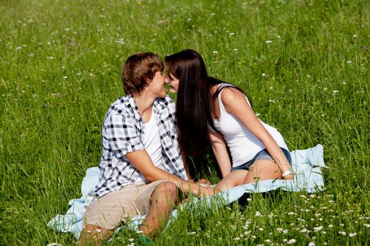 young couple outdoor in summer on blanket in love