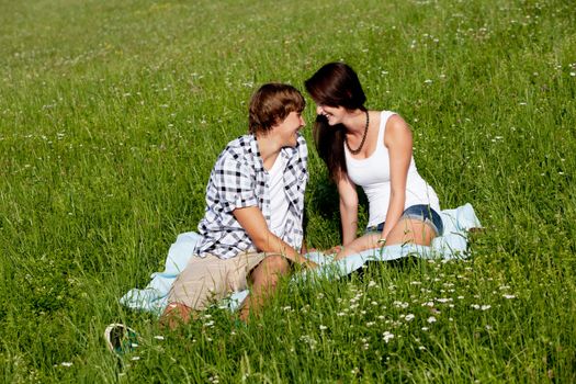 young couple outdoor in summer on blanket in love