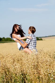 happy couple in love outdoor in summer on field having fun