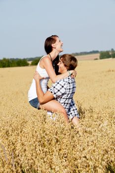 happy couple in love outdoor in summer on field having fun