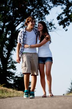 young woman and man is walking on  a road in summer outdoor happy