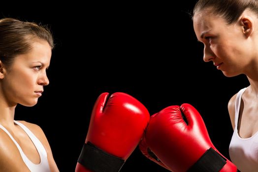 two female boxers face each other, pushing the boxing gloves, start a fight