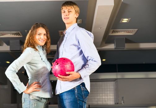 guy hugs her friendgirl, playing together in bowling