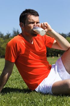 man in a park drinking milk after sport