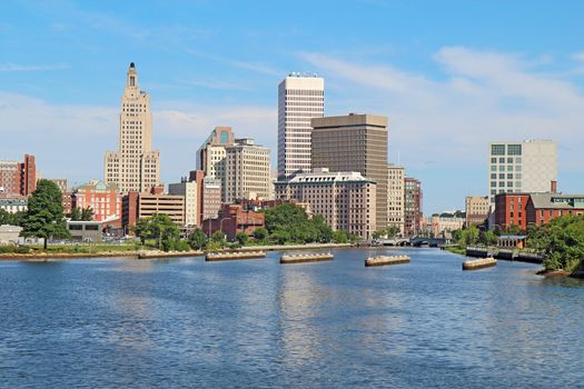 View of the skyline of Providence, Rhode Island, from the far side of the Providence River against a blue sky and white clouds