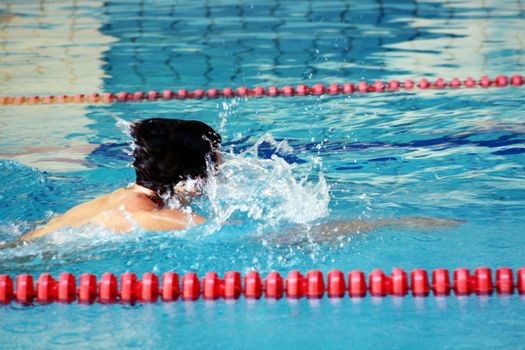 man swims in swimming pool