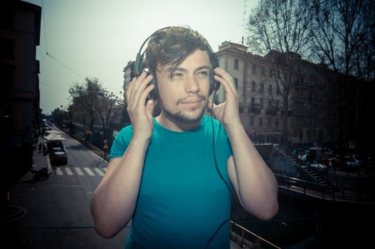 young man hipster listening to music with headphones