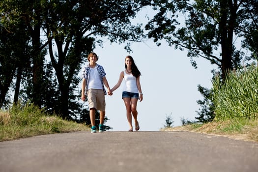 young woman and man is walking on  a road in summer outdoor happy