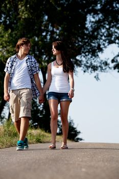 young woman and man is walking on  a road in summer outdoor happy