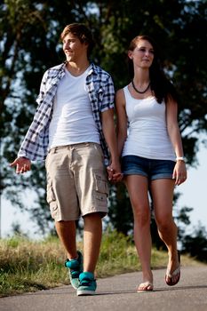 young woman and man is walking on  a road in summer outdoor happy