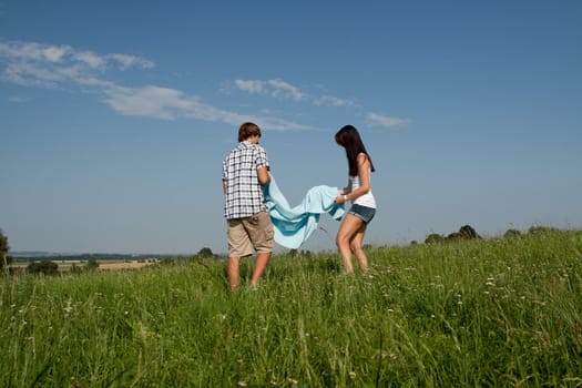 young couple outdoor in summer on blanket in love