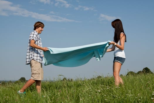 young couple outdoor in summer on blanket in love