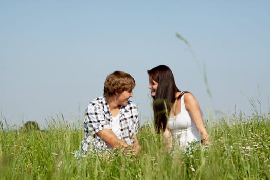 young couple outdoor in summer on blanket in love