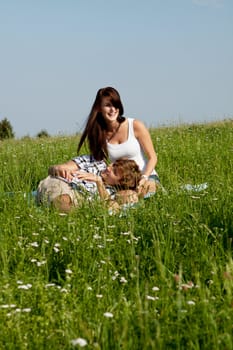 young couple outdoor in summer on blanket in love