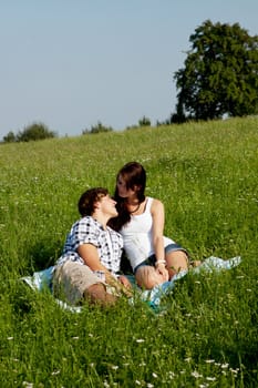 young couple outdoor in summer on blanket in love