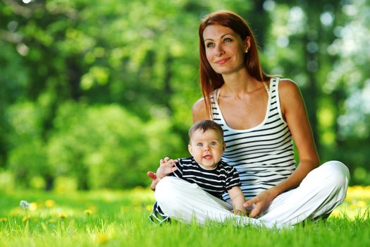 Happy mother and daughter on the green grass