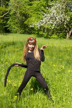 little devil girl in a green field