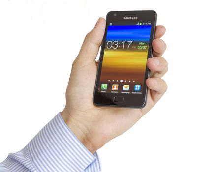 Galati, Romania – July 30, 2012: Hand holding the Samsung Galaxy S2. Samsung Galaxy S2 who has been sold in more than 20 million copies worldwide. Samsungs phone run the latest version of Android, Ice Cream Sandwich, the mobile operating system created by Google.