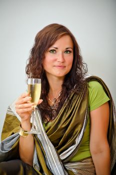 Girl in traditional green clothing with glass of champagne