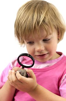 Girl with magnifying glass studying a rock