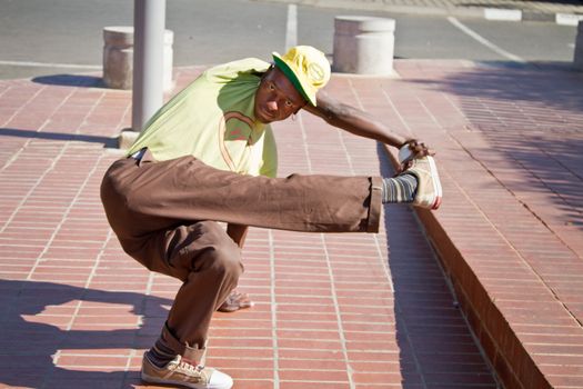 Soweto, South Africa– July 29 – A street performer demonstrates several acrobatic moves showing his body’s unbelievable flexibility near  Mandela’s house on July 29, 2012 in Soweto, South Africa