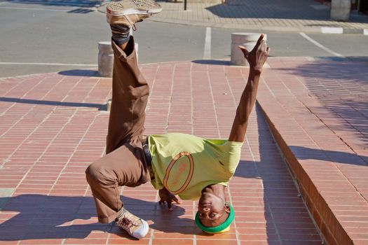 Soweto, South Africa– July 29 – A street performer demonstrates several acrobatic moves showing his body’s unbelievable flexibility near  Mandela’s house on July 29, 2012 in Soweto, South Africa