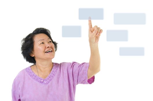 60s Asian senior woman pointing on transparent virtual screen, space for text/button