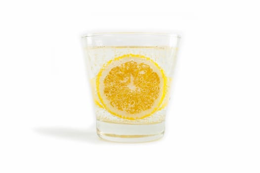 Yellow lemon in soda water on white background