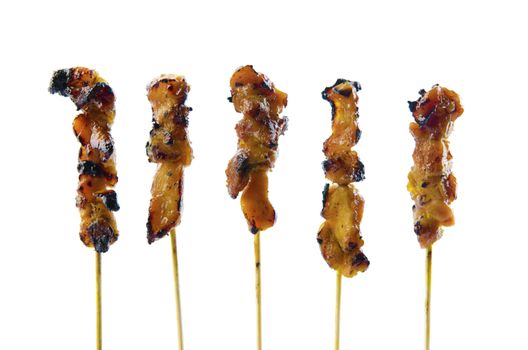 Five satay chicken sticks over white background