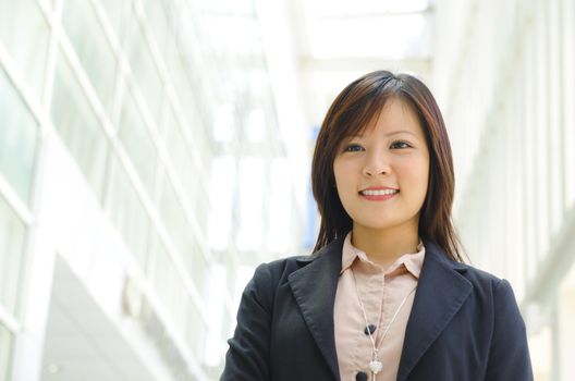 Beautiful Asian officer walking by modern building