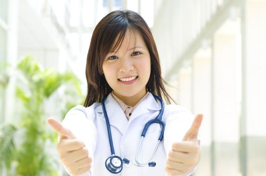 Asian female medical student thumb up showing perfect sign