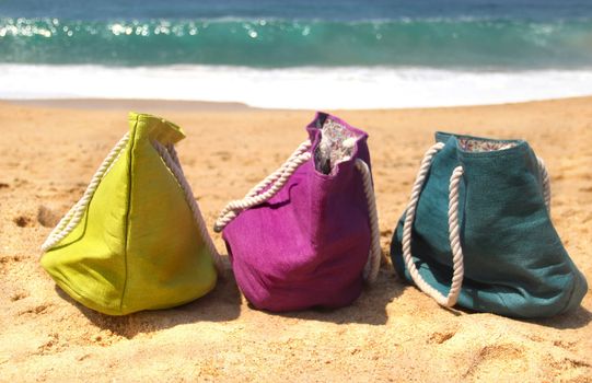 Summer holiday � three vivid bags on the seacoast, green, violet and blue